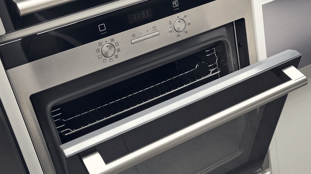 Personne consultant le panneau de commandes d'un four encastrable moderne