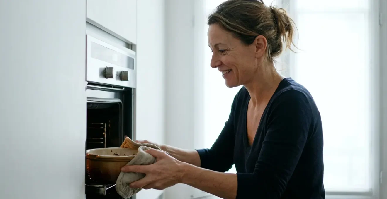 Femme sortant un plat du four encastrable dans une cuisine moderne lumineuse